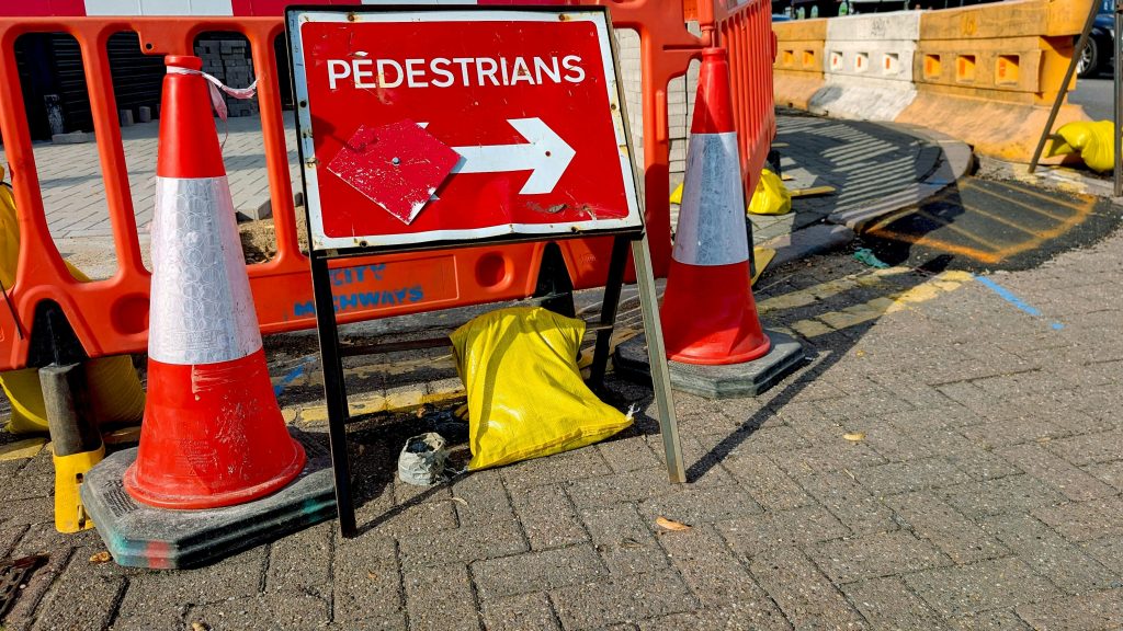Roadworks sign with traffic cones on a city street