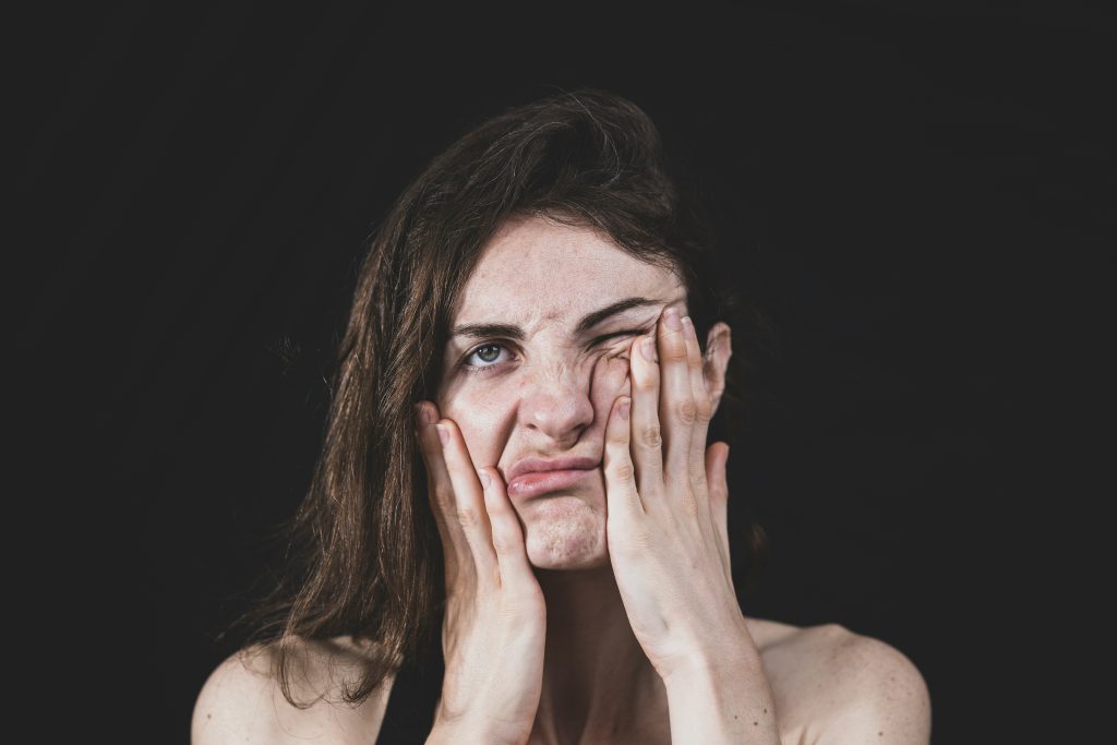 Person covering face with hand in a moment of stress