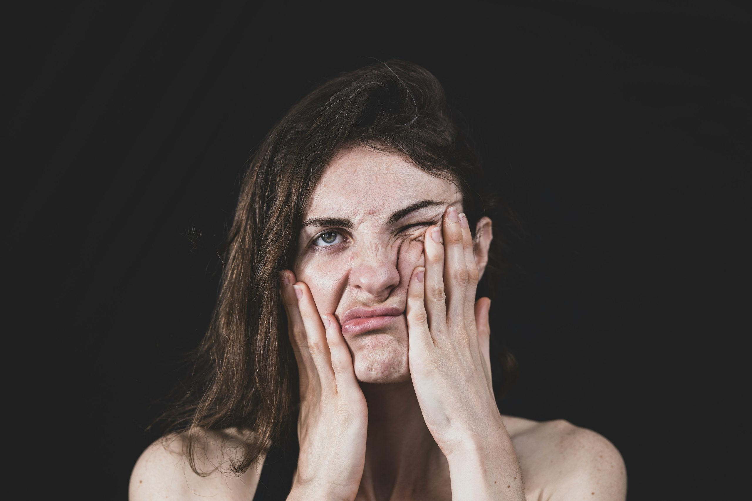 Person covering face with hand in a moment of stress
