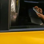 Rideshare passenger using smartphone in the backseat of a cab in Chicago