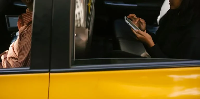 Rideshare passenger using smartphone in the backseat of a cab in Chicago