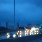 Traffic on a Chicago highway at dusk with the city skyline in the background