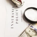 Insurance policy document with magnifying glass and toy car representing injury claims