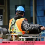 Construction worker wearing safety helmet and vest at an urban construction site