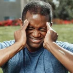 Man massaging temples showing stress and pain representing PTSD and anxiety after accident