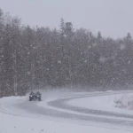 Car navigating a snowy road during winter storm representing black ice accident claims