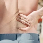 Man holding his lower back in pain representing herniated disc and spinal cord injury claims